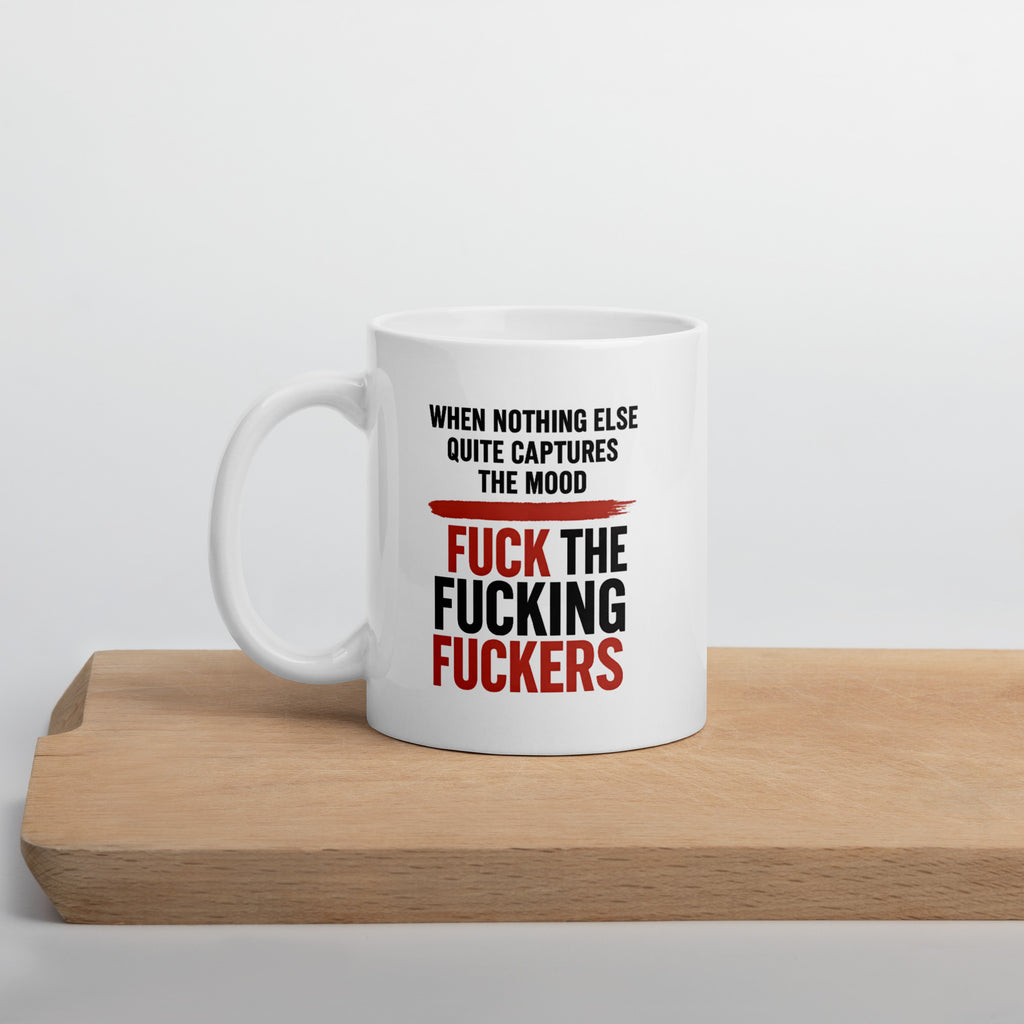 White mug with bold black and red text that says, “When nothing else quite captures the mood, fuck the fucking fuckers.”