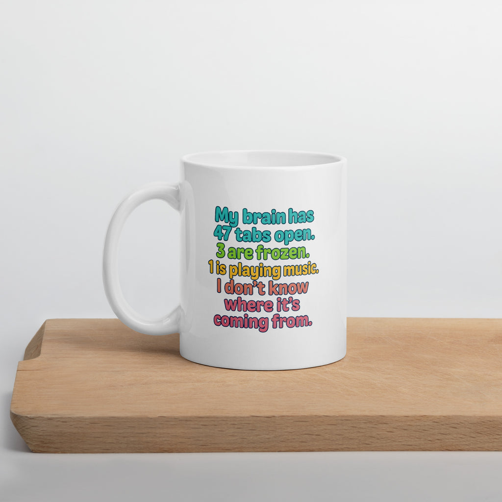 White mug with colorful text that says, “My brain has 47 tabs open. 4 are frozen. 1 is playing music. I don’t know where it’s coming from.”